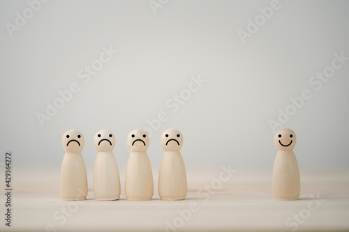 Smiley face on wooden mixture figure separate from sadness face on wooden table , Emotion select and mindset concept.