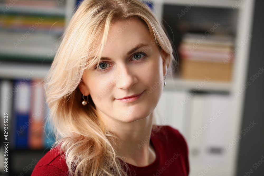 Portrait of young blonde woman on background of folders with documents Portrait of young blonde woman on background of folders with documents