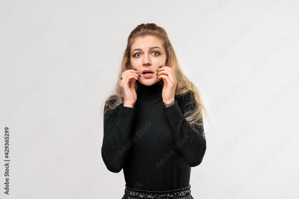 blonde girl looking worried, anxious, stressed and afraid, hold hands near mouth. Studio shot, gray background blonde girl looking worried, anxious, stressed and afraid, hold hands near mouth. Studio shot, gray background