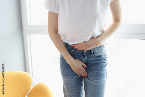 Woman holding her belly and groin area with her hand closeup