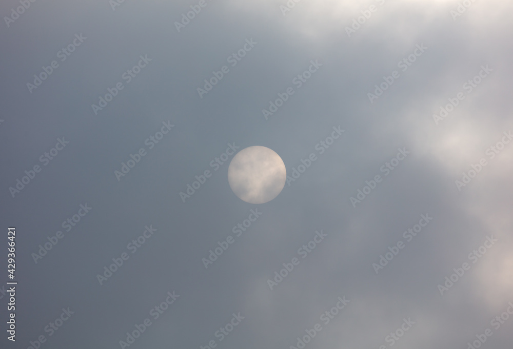 The sun shines behind the clouds during The sun shines behind the clouds during