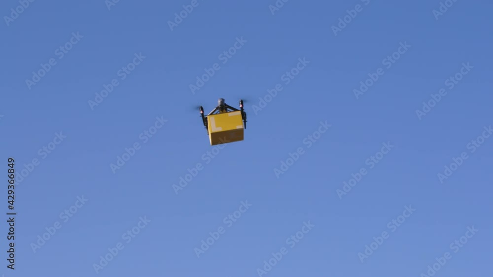 delivery drone carrying parcel flying across the blue sky delivery drone carrying parcel flying across the blue sky
