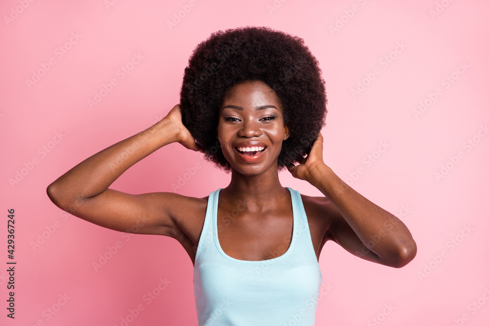Portrait of optimistic brunette curly lady touch hair wear blue top isolated on pastel pink color background Portrait of optimistic brunette curly lady touch hair wear blue top isolated on pastel pink color background