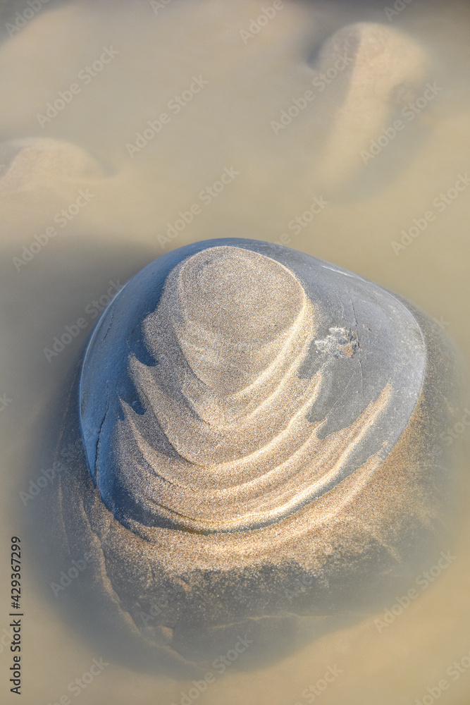 Sand forms abstract shape on the rocks as the tide goes out Sand forms abstract shape on the rocks as the tide goes out