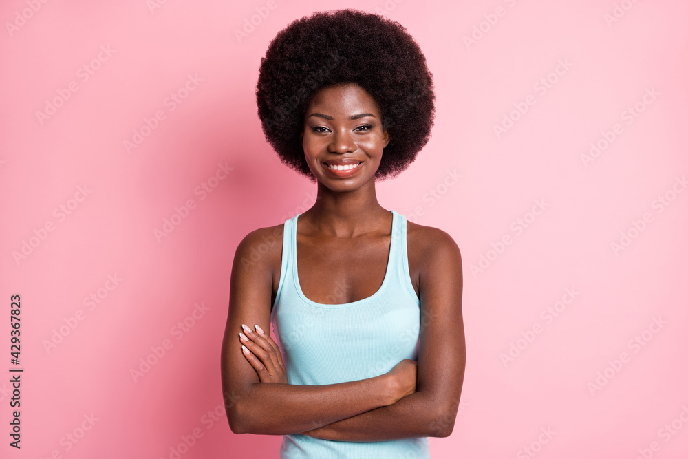 Portrait of optimistic brunette curly lady crossed arms wear blue top isolated on pink color background Portrait of optimistic brunette curly lady crossed arms wear blue top isolated on pink color background