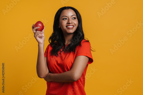 Young black happy woman smiling while posing with apple