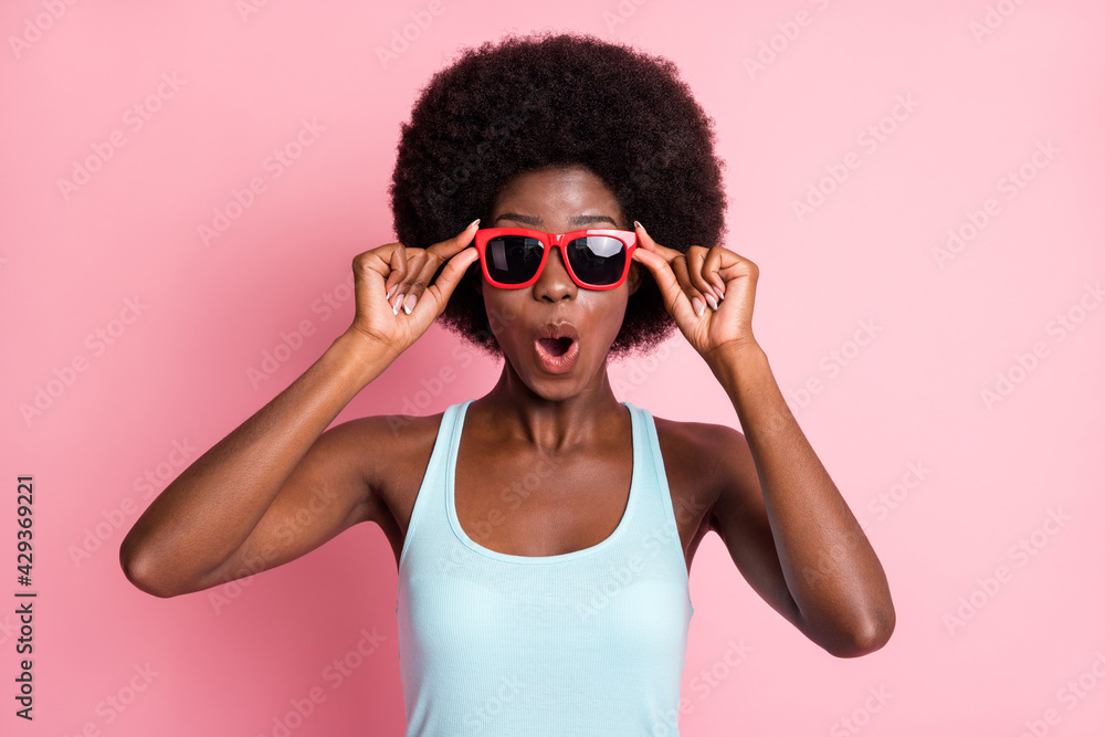Portrait of impressed brunette curly lady wear spectacles blue top isolated on pastel pink color background Portrait of impressed brunette curly lady wear spectacles blue top isolated on pastel pink color background