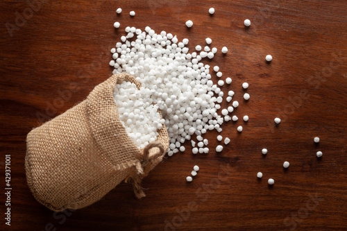 Tableau sur toile Close-up of organic white sago or sabudana big size spilled out from a laying jute bag over a wooden brown background