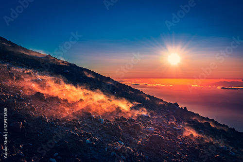 Marvelous sunset over the horizon  haze coming from the warm ground of an active volcano