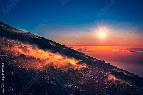 Marvelous sunset over the horizon, haze coming from the warm ground of an active volcano