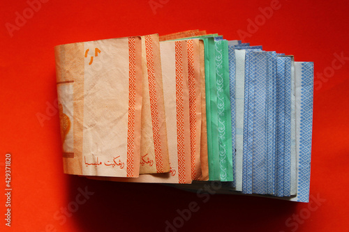 Stack of Malaysia Ringgit banknotes on red background