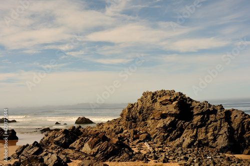 A contrast of rough and rugged rocks against soft clouds and blue sky at Keurbooms on the Garden Route, Western Cape