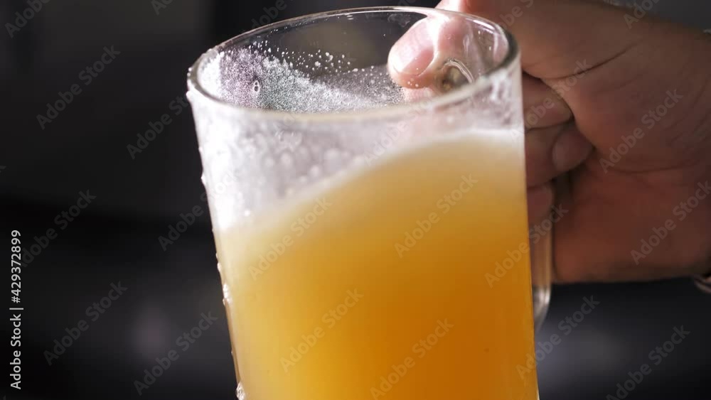 A successful expert brewer with a beard evaluates freshly brewed beer from a beer tank while standing in a beer factory. A modern beer factory. Brewing. Production. Close-up A successful expert brewer with a beard evaluates freshly brewed beer from a beer tank while standing in a beer factory. A modern beer factory. Brewing. Production. Close-up