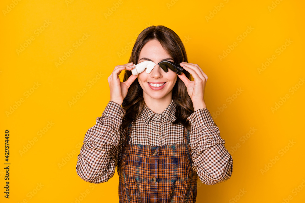 Photo portrait of brunette keeping chess figures playful childish hiding eyes smiling isolated on vibrant yellow color background Photo portrait of brunette keeping chess figures playful childish hiding eyes smiling isolated on vibrant yellow color background