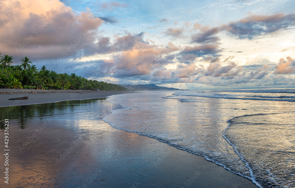 Beautiful sunset sky with clouds on the beach in Matapalo, Costa Rica. Central America. Sky background on sunset. Tropical sea.