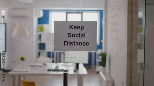 Business glass interior office with keep social distance sign on the wall. Modern office space with nobody in it during global pandemic  coronavirus crisis