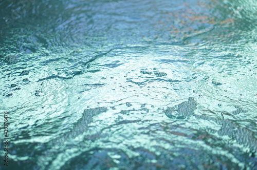water surface in a swimming pool with waves, air bubbles, and refraction of light