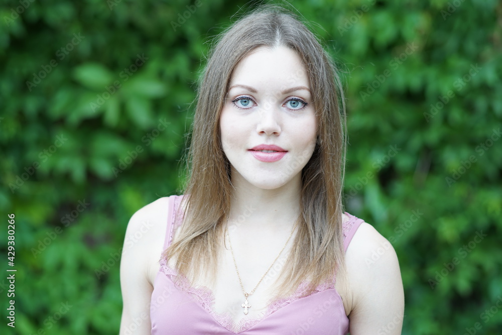 Naklejka premium Portrait of a young beautiful girl in the park