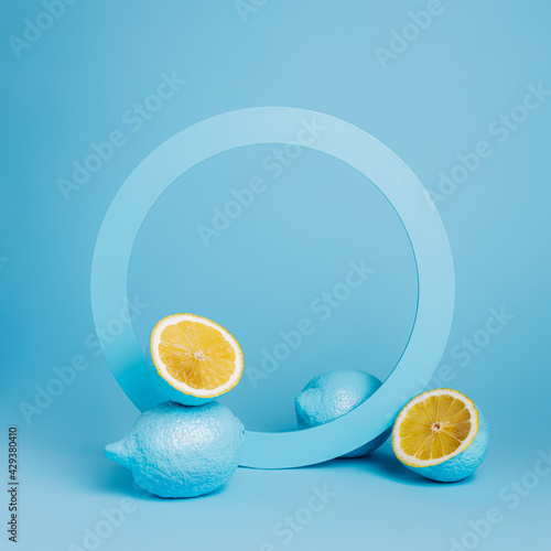 Product podium and frame for copy space with blue lemons on blue background. Concept scene stage showcase for juice, cocktails or fruit related products. Minimal summer empty mock up template.
