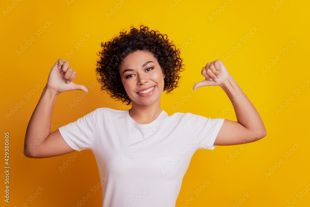 Portrait of young woman pointing finger herself on yellow background Portrait of young woman pointing finger herself on yellow background