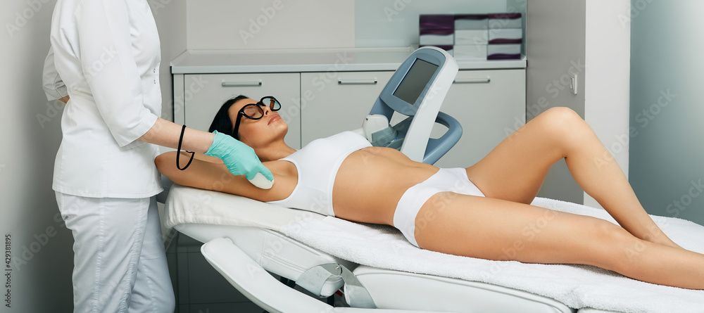 Laser armpit hair removal. Beautician removes hair on female armpit using a  medical laser for epilation Stock Photo | Adobe Stock