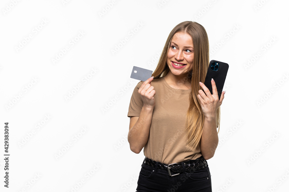 Young woman holding credit card and using smartphone isolated on a white background Young woman holding credit card and using smartphone isolated on a white background
