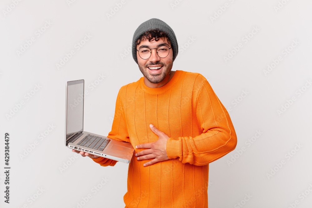 nerd man with computer laughing out loud at some hilarious joke, feeling happy and cheerful, having fun - obrazy, fototapety, plakaty 