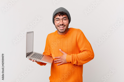 Quadro su tela nerd man with computer laughing out loud at some hilarious joke, feeling happy a