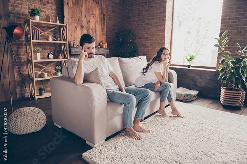 Full size photo of unhappy upset negative mood couple having conflict crisis problems ignoring each other sit sofa at home