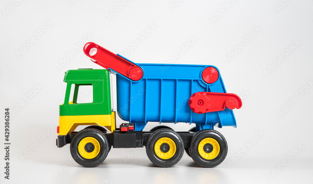 Multi-colored plastic children's toy cars on a white background. Truck. Multi-colored plastic children's toy cars on a white background. Truck.
