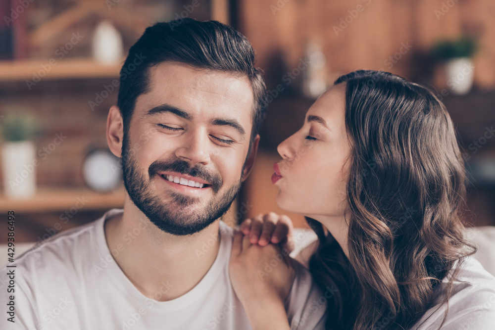Naklejka premium Close-up portrait of two passionate attractive amorous dreamy cheerful people kissing enjoying staying home indoors