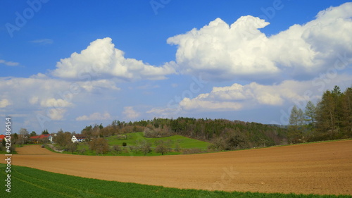 idyllisches Dorf Mindersbach am Rand von  Feld und Wiesen unter schönem Wolkenhimmel im Frühling  © globetrotter1