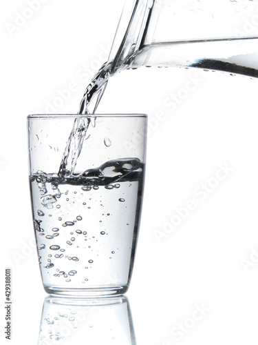 Wallpaper Mural Glass of water being filled. Close up pouring clear water in transparent drinking glass over white background Torontodigital.ca