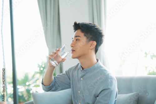 portrait of a young man drinking a water glass
