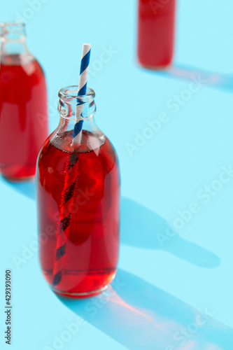 Summer iced cranberrie punch cocktail in bottle on blue background photo