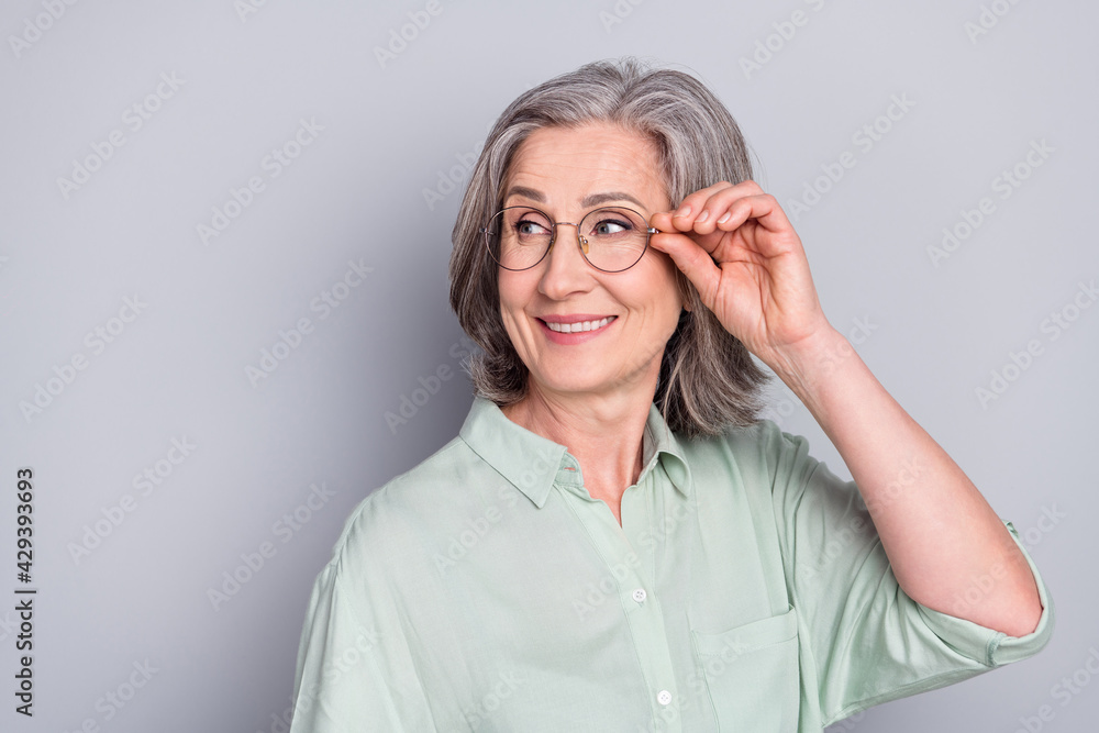 Photo of happy smiling dreamy mature businesswoman in glasses look copyspace isolated on grey color background Photo of happy smiling dreamy mature businesswoman in glasses look copyspace isolated on grey color background