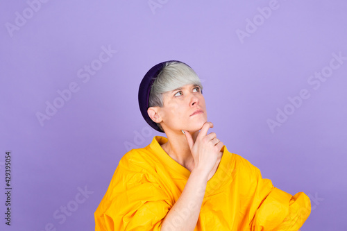 Stylish european woman on purple  background thinking worried looking aside concerned © Анастасия Каргаполов
