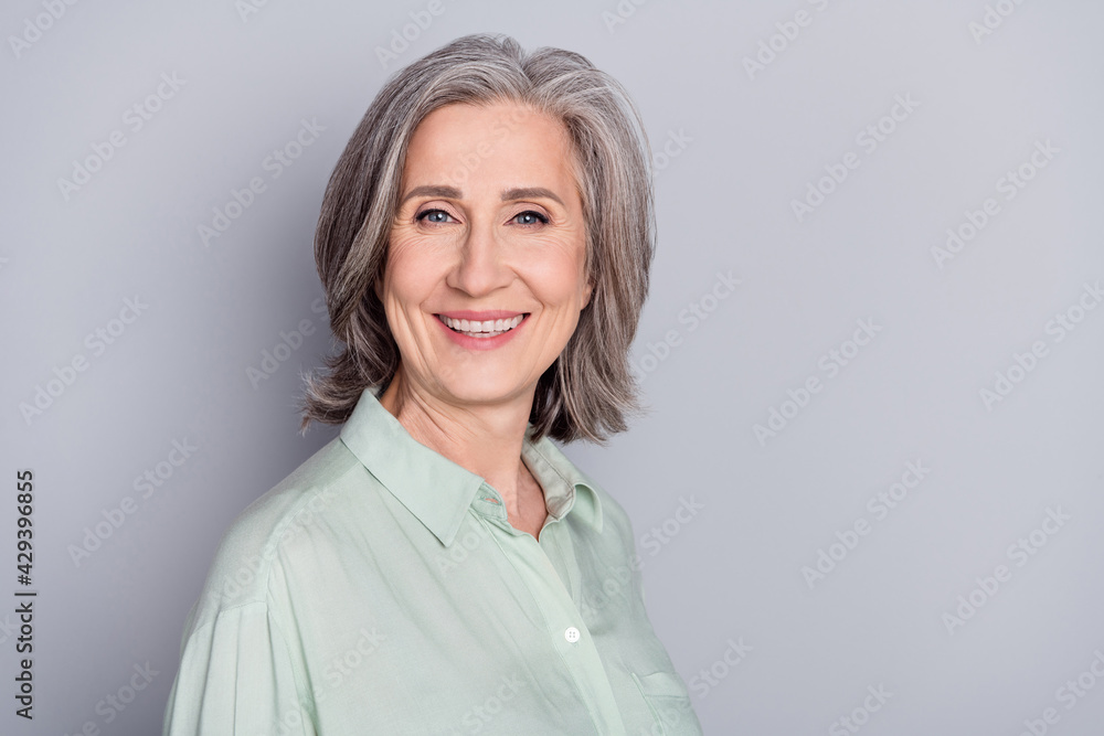 Photo of happy smiling beautiful lovely mature woman granny laughing wear green shirt isolated on grey color background Photo of happy smiling beautiful lovely mature woman granny laughing wear green shirt isolated on grey color background