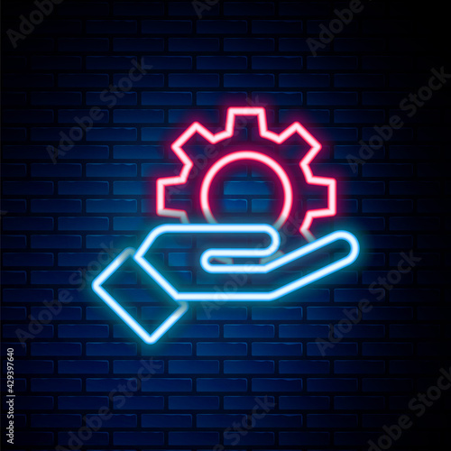 Glowing neon line Hand settings gear icon isolated on brick wall background. Adjusting, service, maintenance, repair, fixing. Colorful outline concept. Vector