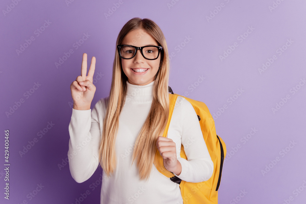Young woman showing two fingers peace gesture carry backpack Young woman showing two fingers peace gesture carry backpack