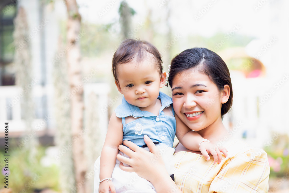 Fototapeta premium Happy mother and daughter walking in the garden