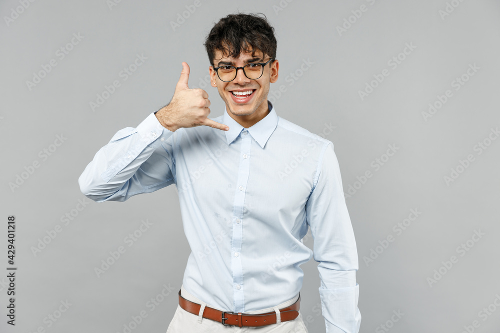 Young successful employee business latin man corporate lawyer in classic white shirt glasses doing phone gesture say call back isolated on grey background studio portrait Career achievement concept Young successful employee business latin man corporate lawyer in classic white shirt glasses doing phone gesture say call back isolated on grey background studio portrait Career achievement concept