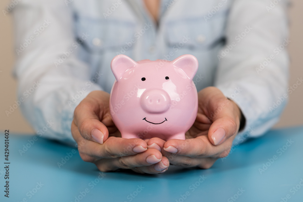 Piggy bank in hand on blue background, space for text. Finance, saving money. Business to success and saving for retirement concept
