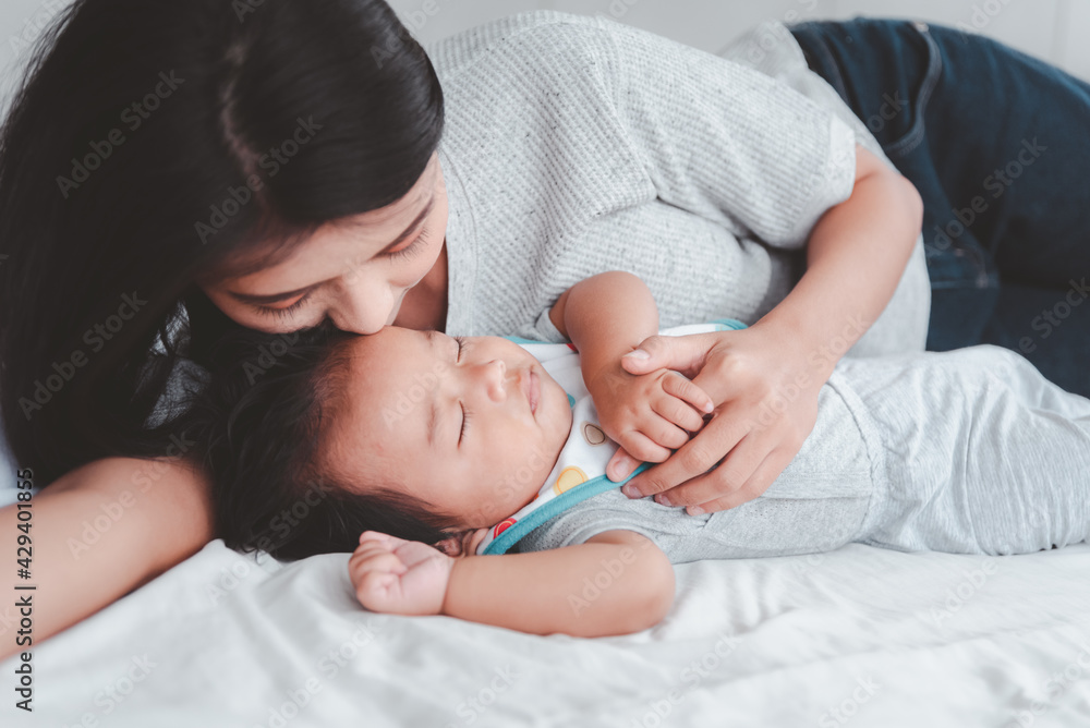 Young beautiful aisan mother kissing her baby. Young beautiful aisan mother kissing her baby.
