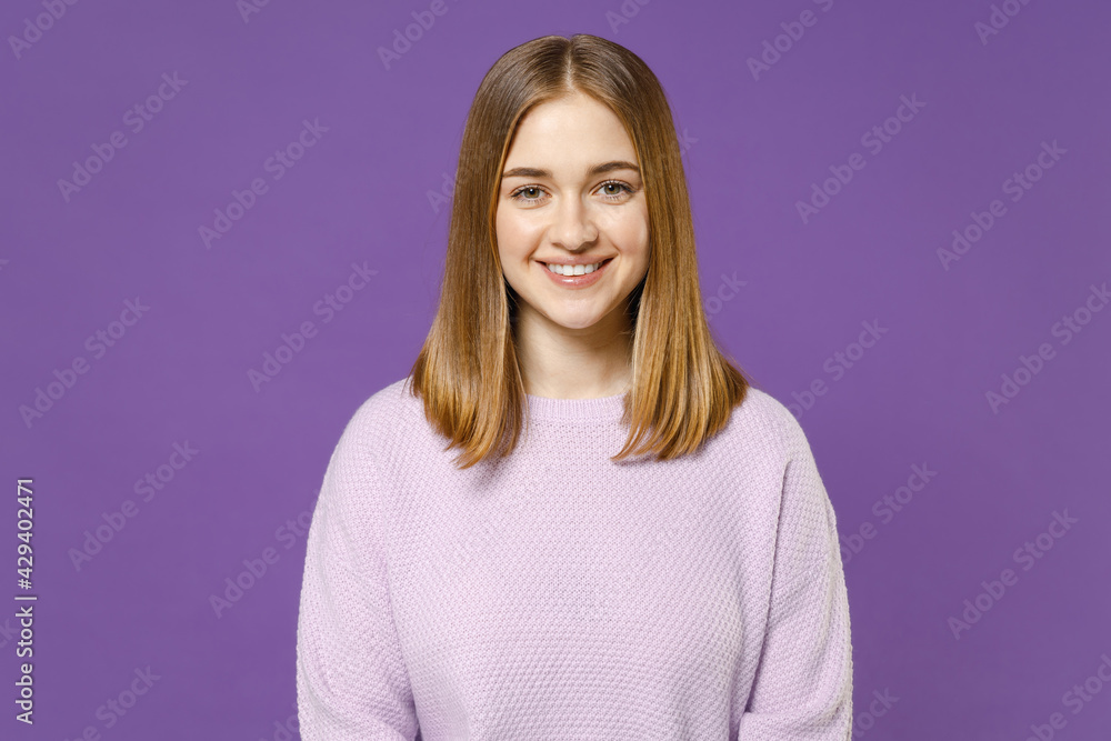 Young smiling positive happy friendly cheerful student caucasian woman 20s wearing purple knitted sweater looking camera isolated on violet color background studio portrait People lifestyle concept. Young smiling positive happy friendly cheerful student caucasian woman 20s wearing purple knitted sweater looking camera isolated on violet color background studio portrait People lifestyle concept.