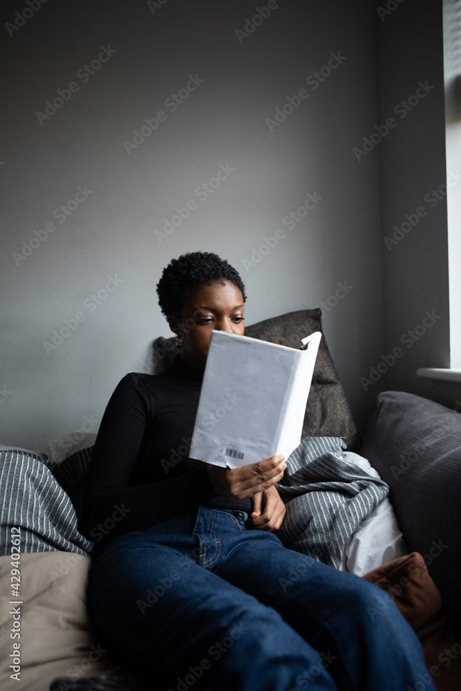Woman reading a book from her comfortable sofa Woman reading a book from her comfortable sofa