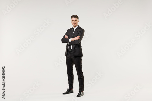 Full length young successful employee business corporate lawyer man in classic formal black grey suit shirt tie work in office hold hands crossed folded isolated on white background studio portrait