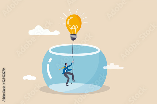 Innovation to solve business problem, idea and creativity to achieve business success concept, businessman climbing the rope from light bulb idea to escape prison fish bowl. photo