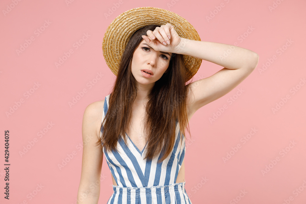 Young tired sick puzzled troubled caucasian woman 20s wearing summer clothes dress straw hat rub put hand on forehead look camera isolated on pastel pink background studio. People lifestyle concept. Young tired sick puzzled troubled caucasian woman 20s wearing summer clothes dress straw hat rub put hand on forehead look camera isolated on pastel pink background studio. People lifestyle concept.