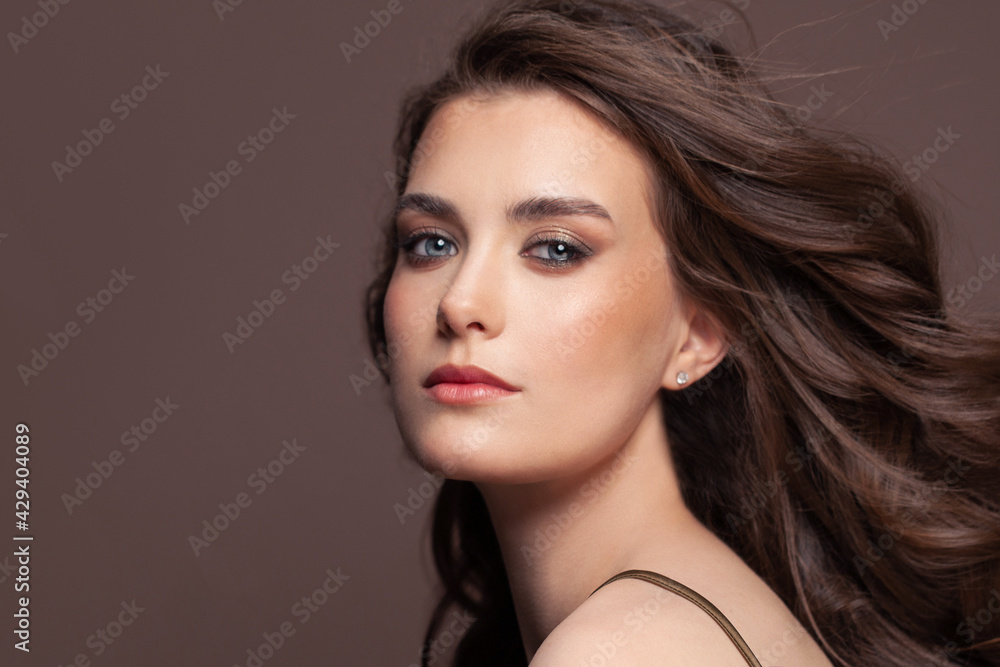 Portrait of perfect fashion model woman with clear skin on brown Portrait of perfect fashion model woman with clear skin on brown